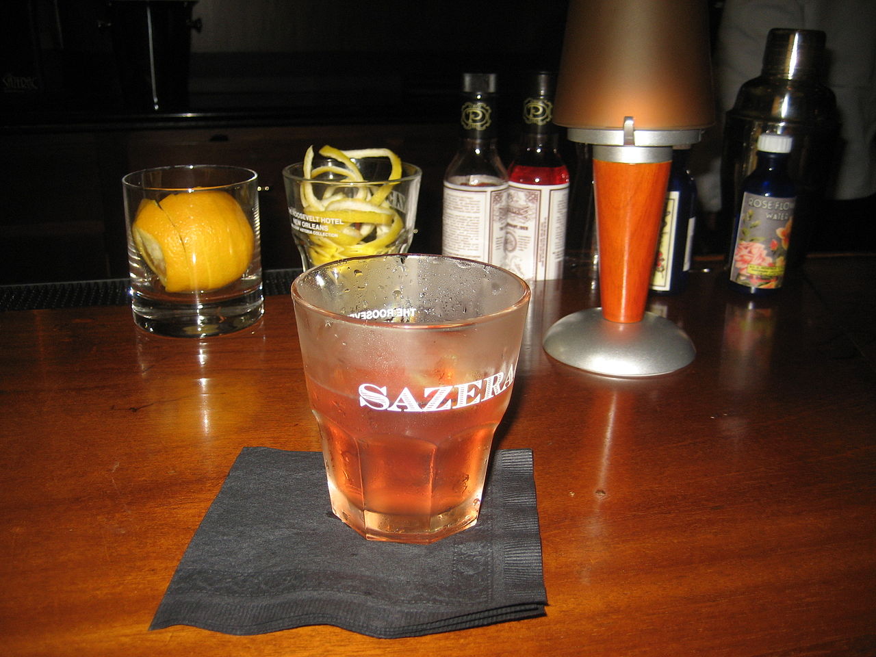 glass full of sazerac on a bar table