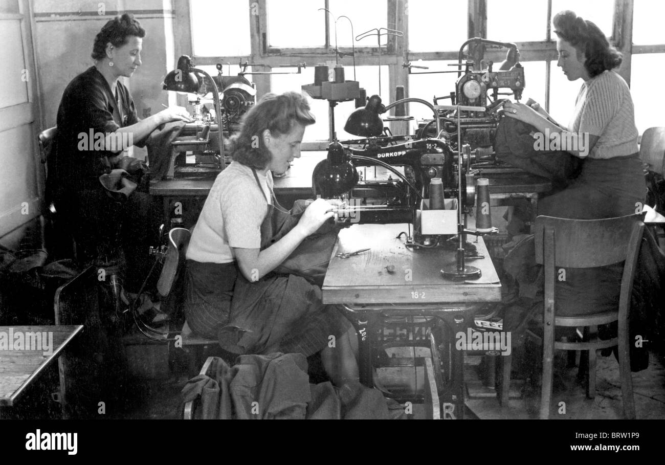 Early day sewing woman sitting around sewing machines